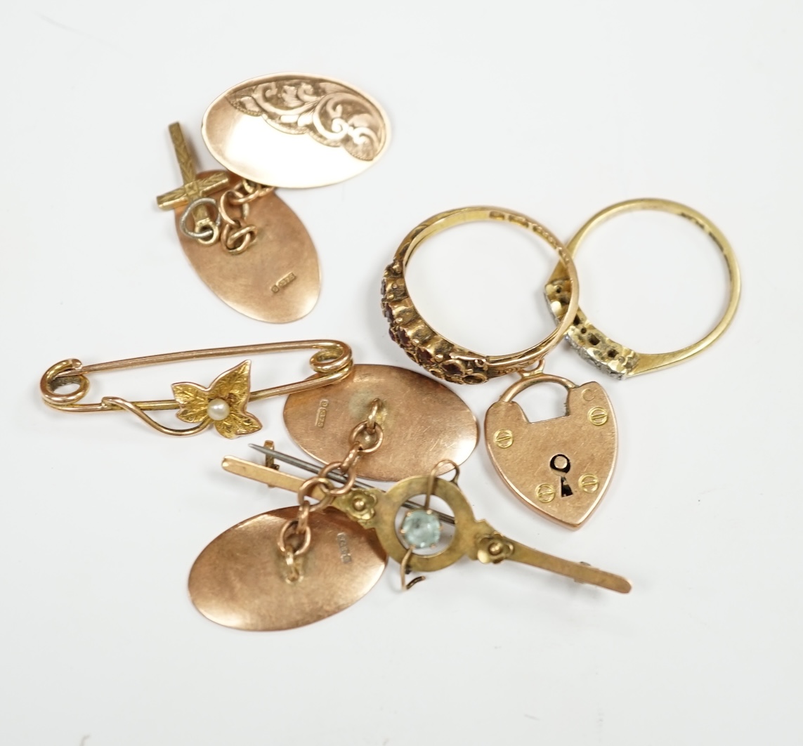 A pair of engraved 9ct gold oval cufflinks, two yellow metal bar brooches including 9ct, a 15ct gold and gem set ring (lacking stones), an 18ct and five stone diamond chip set ring and two 9ct charms. Condition - poor to